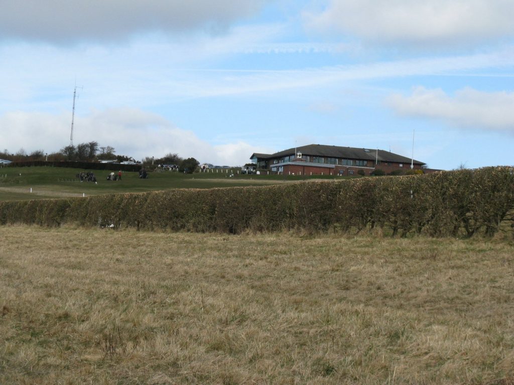 Golfers hitting balls on the practice range at the Dyke Golf Club